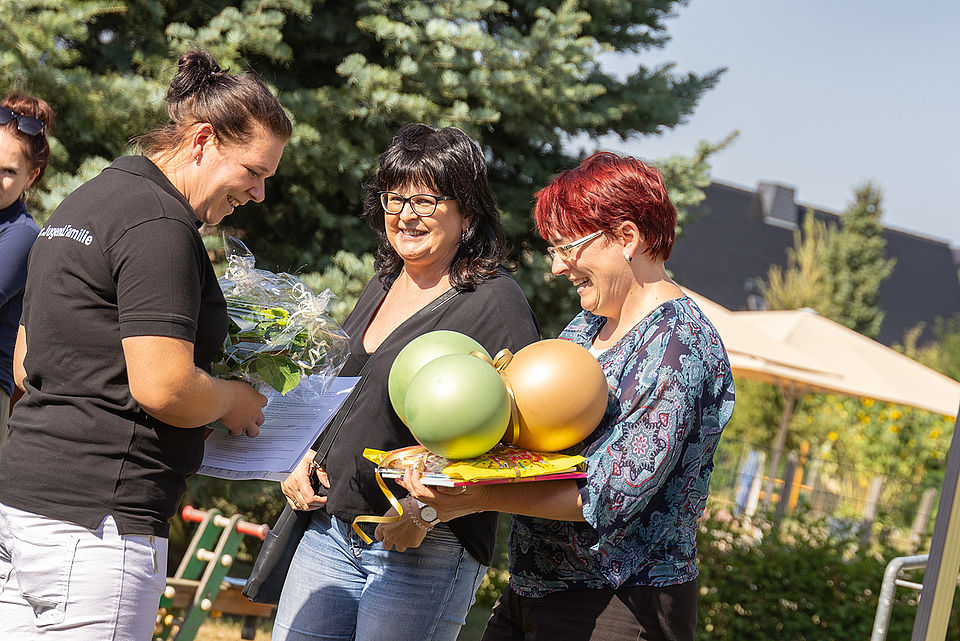 Spielende Kinder und Erwachsene bei einer Festrede auf dem Gelände des Kinderhaus "Villa Motschekiebchen" Falkenhain