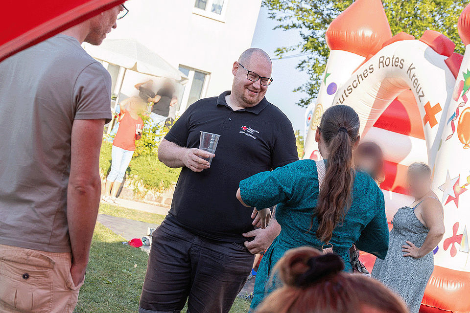 Spielende Kinder und Erwachsene bei einer Festrede auf dem Gelände des Kinderhaus "Villa Motschekiebchen" Falkenhain