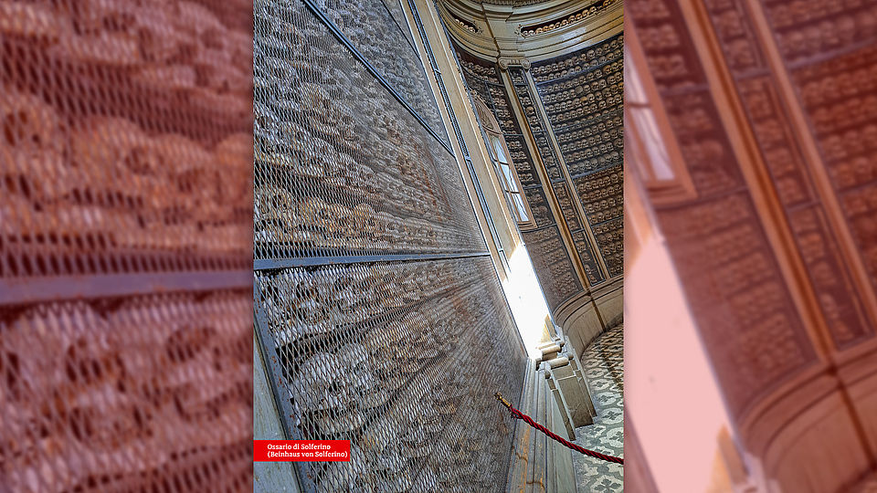 Innenansicht des Ossariums in Solferino. Zahlreiche menschliche Schädel und Knochen sind ordentlich in Regalen und Nischen gestapelt und angeordnet, was die große Anzahl der Opfer der Schlacht von Solferino verdeutlicht.