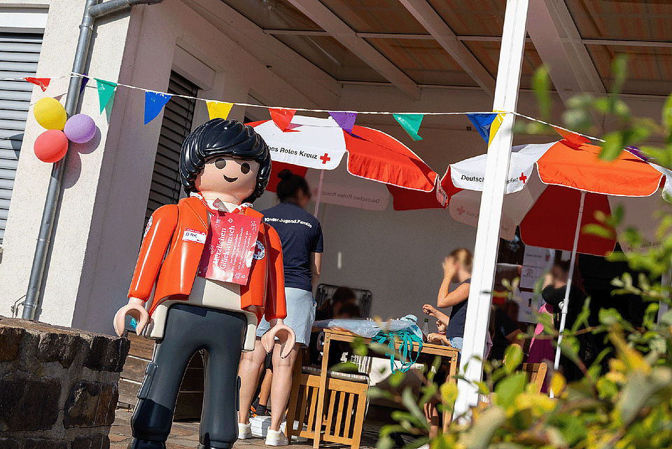 Spielende Kinder und Erwachsene bei einer Festrede auf dem Gelände des Kinderhaus "Villa Motschekiebchen" Falkenhain